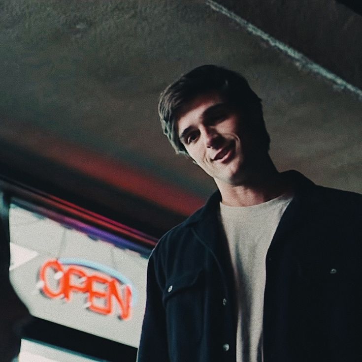 a man standing in front of a neon sign