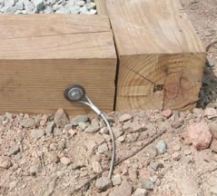 a wooden box sitting on top of a pile of rocks next to a fire hydrant