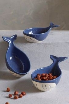 three blue whale bowls with nuts in them