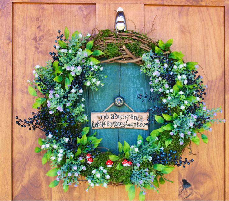 a green door with a wreath hanging on it's side and a sign that says, no adventure is impossible