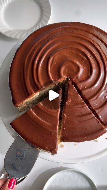 a person cutting into a chocolate cake with a knife