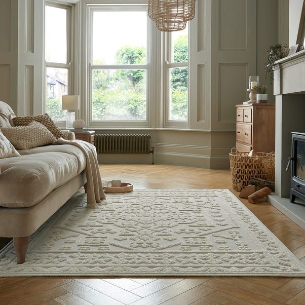 a living room with a couch, rug and fireplace