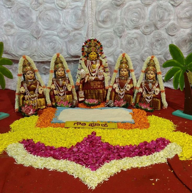 a group of statues sitting on top of a table covered in flowers and grass next to each other