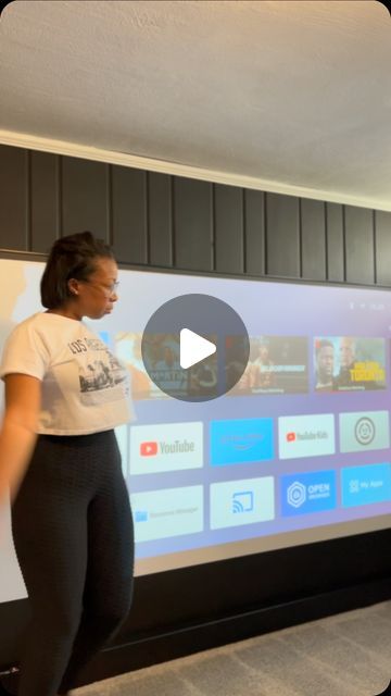 a woman standing in front of a projector screen