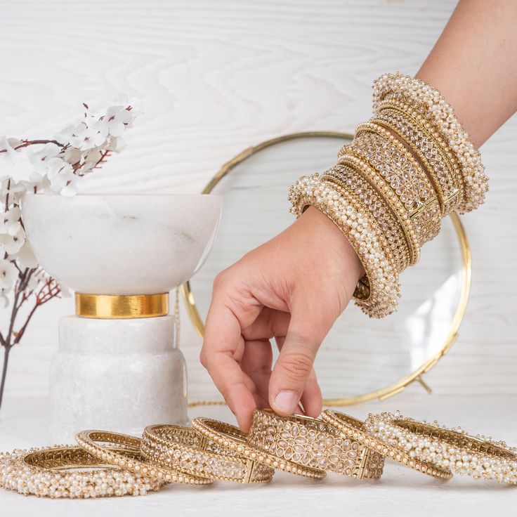 Beautify your traditional look with an elegant set embodying culture and style! This luxurious bridal bangle set is designed with exquisite gajra bangles and champagne stones that will make you sparkle with beauty on your big day. Available in various sizes. Gold-plated on high-quality brass as base metal.Size 2.6 & Size 2.8 (Single set) is in-stock and ready to ship. *Please Note: We use faux stones and beads in all of our jewelry. Gold Beaded Bangle For Wedding, Bollywood Style Bangle For Diwali Wedding, Traditional Beaded Bangle For Wedding, Bollywood Bangle For Wedding And Diwali, Bollywood Style Wedding Bangle For Diwali, Traditional Wedding Beaded Bangle, Gold Bridal Accessories For Reception And Festivals, Hand Set Gold Bollywood Bridal Accessories, Bollywood Style Gold Bridal Accessories With Hand Set Details