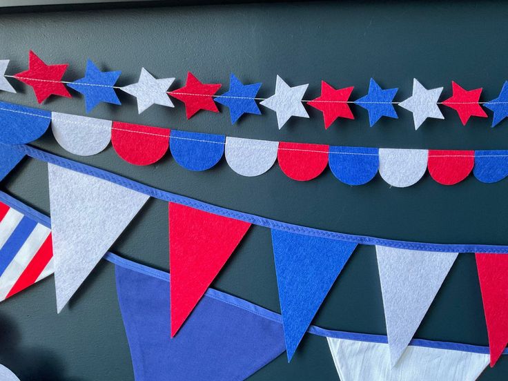 red, white and blue buntings are hanging from the side of a wall