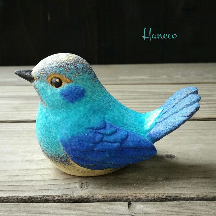 a blue bird sitting on top of a wooden table