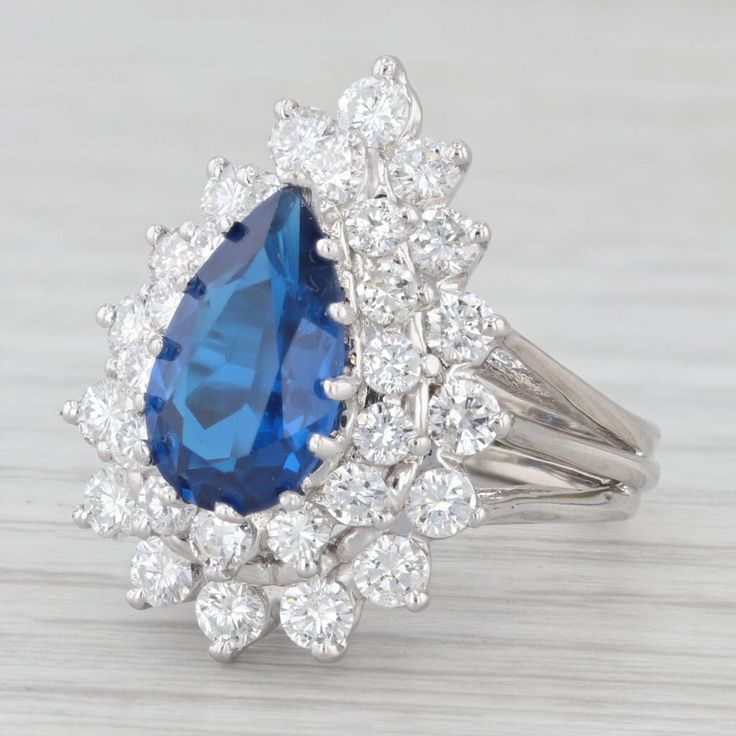 Gemstone Information: - Lab Grown Spinel - Total Carats - 2.4ct Cut - Pear Color - Blue - Natural Diamonds - Total Carats - 1.64ctw Cut - Round Brilliant Color - F - G Clarity - SI1-I1 Metal: 14K White Gold Weight: 8.2 Grams  Stamps: 14K Face Height: 23.2 mm  Rise Above Finger: 12.6 mm Band / Shank Width: 4 mm This ring is a size 5.75, but it can be resized down 1 sizes for a $25 fee or up 2 sizes for a $60 fee. Please type in "Ring Sizing Fee" in the search bar if you wish to have this ring sized. If you would like your ring resized, please select the appropriate fee from the listing below in order to pay the sizing fee: https://www.etsy.com/listing/781388346/ring-sizing-service-fee Each piece is thoroughly examined and refinished as needed by our professional jewelers, graded by our in-h Pear-shaped Halo Ring For Formal Occasions, Pear-shaped Blue Diamond Ring For Formal Occasions, Blue Pear-shaped Diamond Ring For Formal Occasions, Teardrop Sapphire Ring With Diamond, Classic Pear-shaped Cluster Ring For Formal, Formal Blue Pear-shaped Diamond Ring, Formal Teardrop Diamond Ring With Halo Setting, Formal Pear-shaped Diamond Ring With Halo Setting, Elegant Pear-shaped Sapphire Ring For Formal Occasions