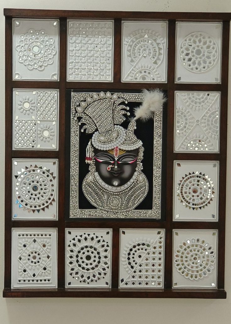 an intricately designed wall hanging on the side of a building with decorative glass panels