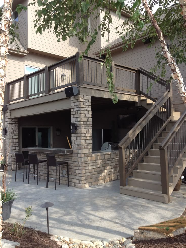 an outdoor patio with stairs leading up to the deck and dining room table on the other side