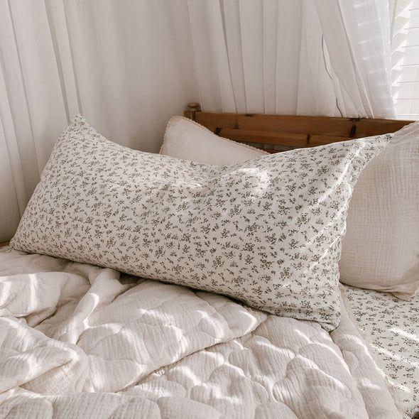 a bed with white sheets and pillows on top of it