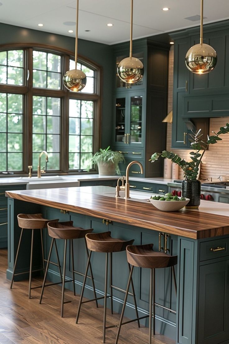 a kitchen with green cabinets and wooden counter tops, three stools in front of the island