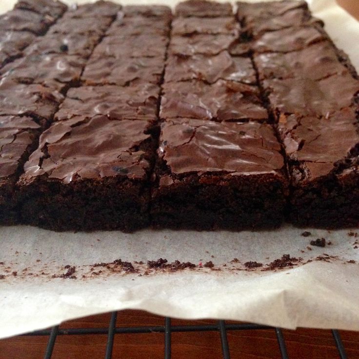 chocolate brownies sitting on top of a white paper towel next to a cooling rack