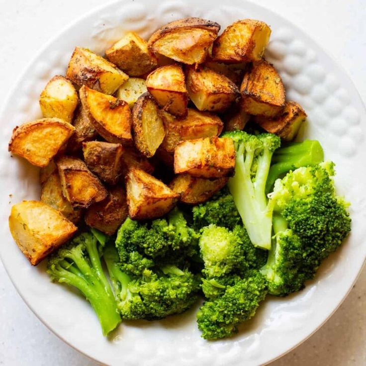 a white plate topped with potatoes and broccoli