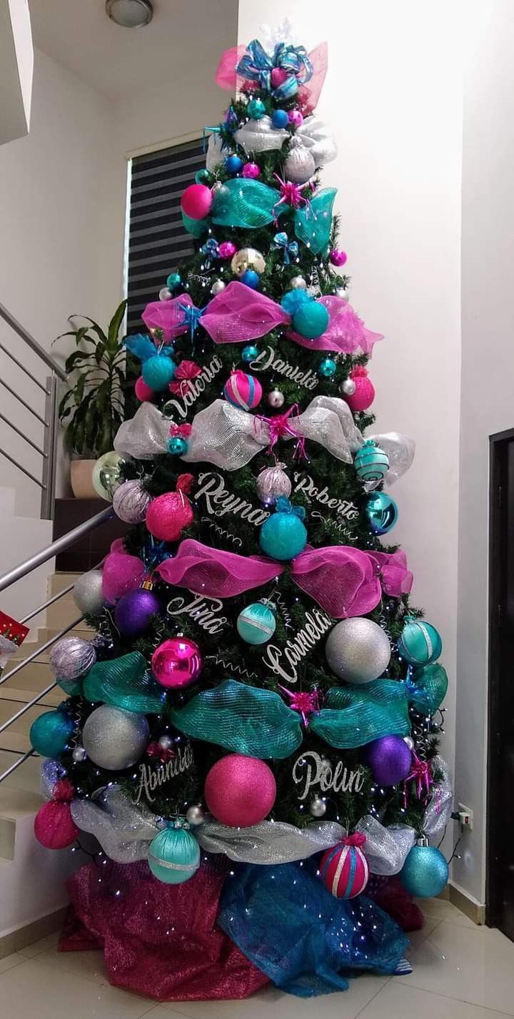 a decorated christmas tree with pink, blue and green ornaments on it's bottom