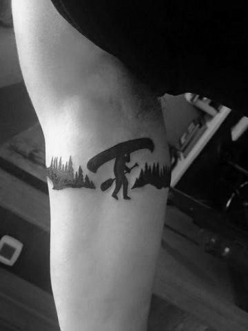 a man with a tattoo on his leg that has a bear and trees on it