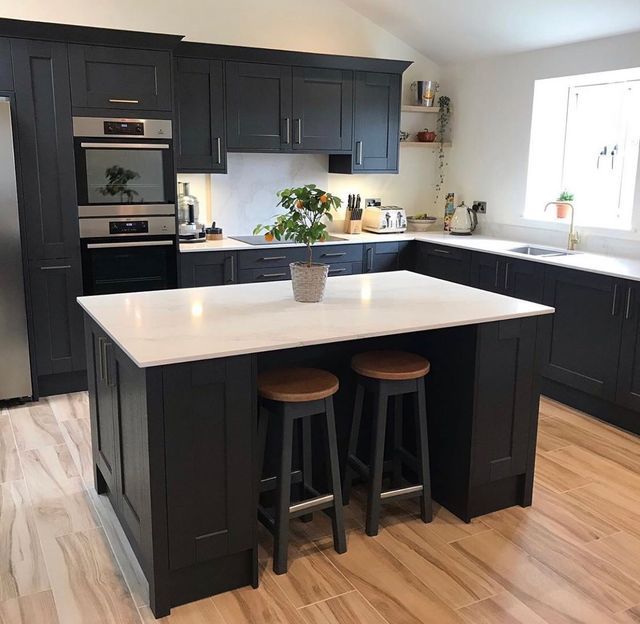 a kitchen with two stools in the center and an island on the other side