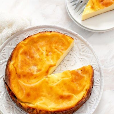 a piece of cheese pie on a plate with a fork and knife next to it