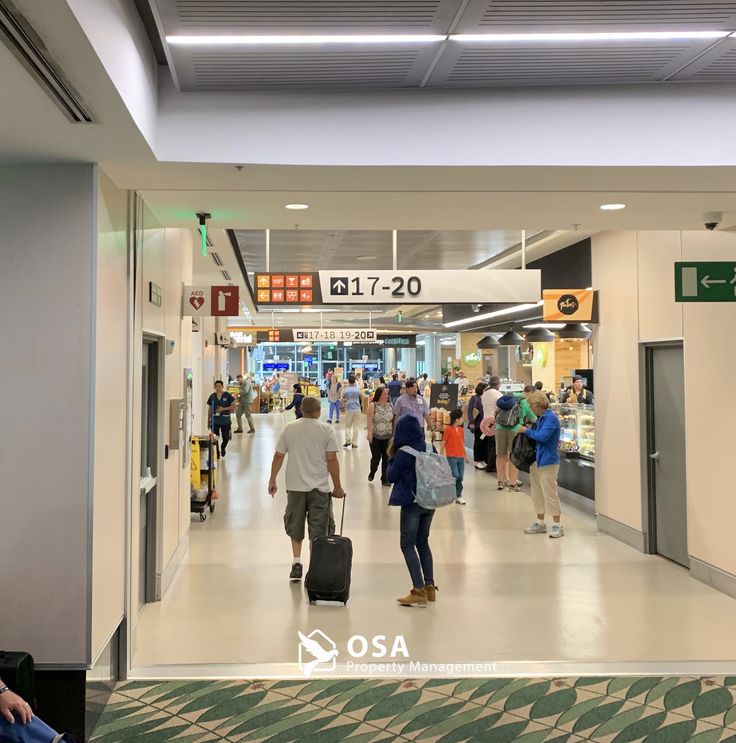 people are walking through an airport with their luggage