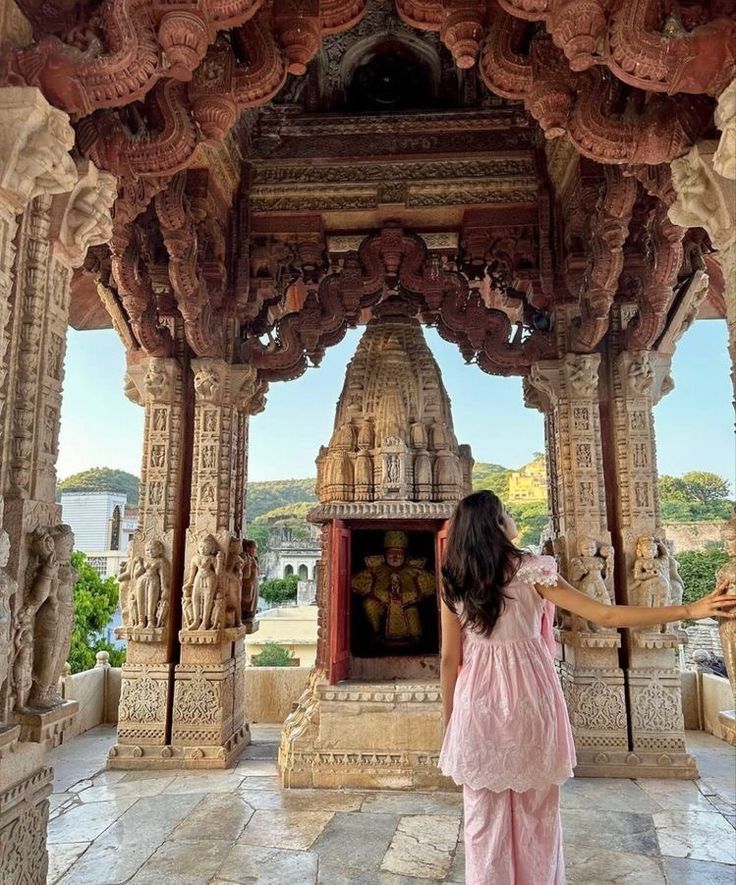 a woman standing in front of an ornate structure