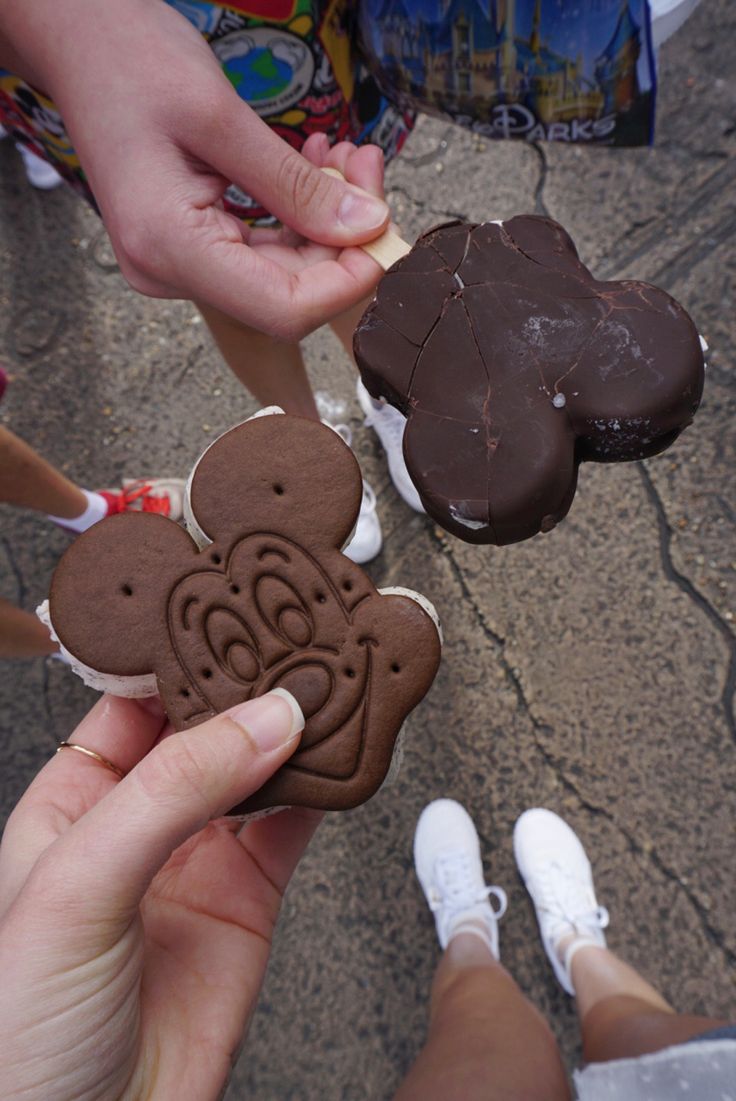 some people are holding cookies in their hands and one has a cookie shaped like a dog