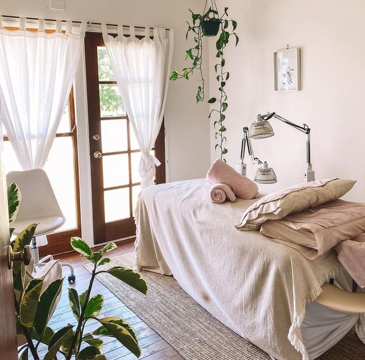 a bedroom with a bed, window and plants on the wall next to the door