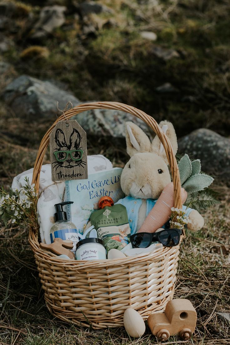 a basket filled with items sitting on top of a grass covered field next to rocks