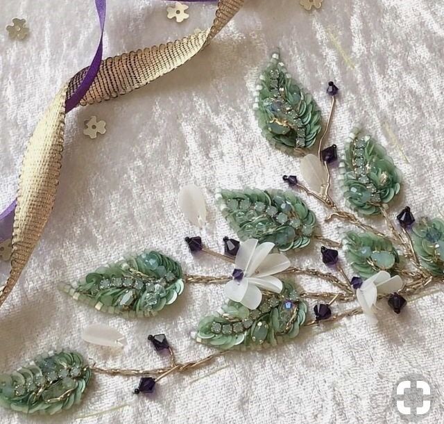 a close up of a piece of cloth with flowers and leaves on it next to a ribbon