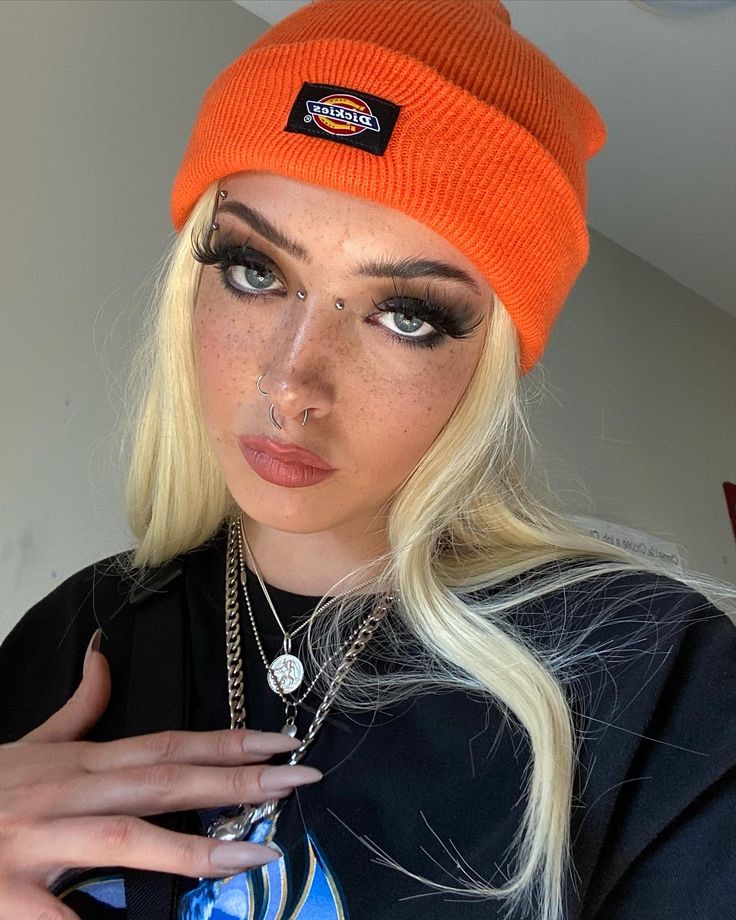 a woman with blonde hair wearing an orange beanie