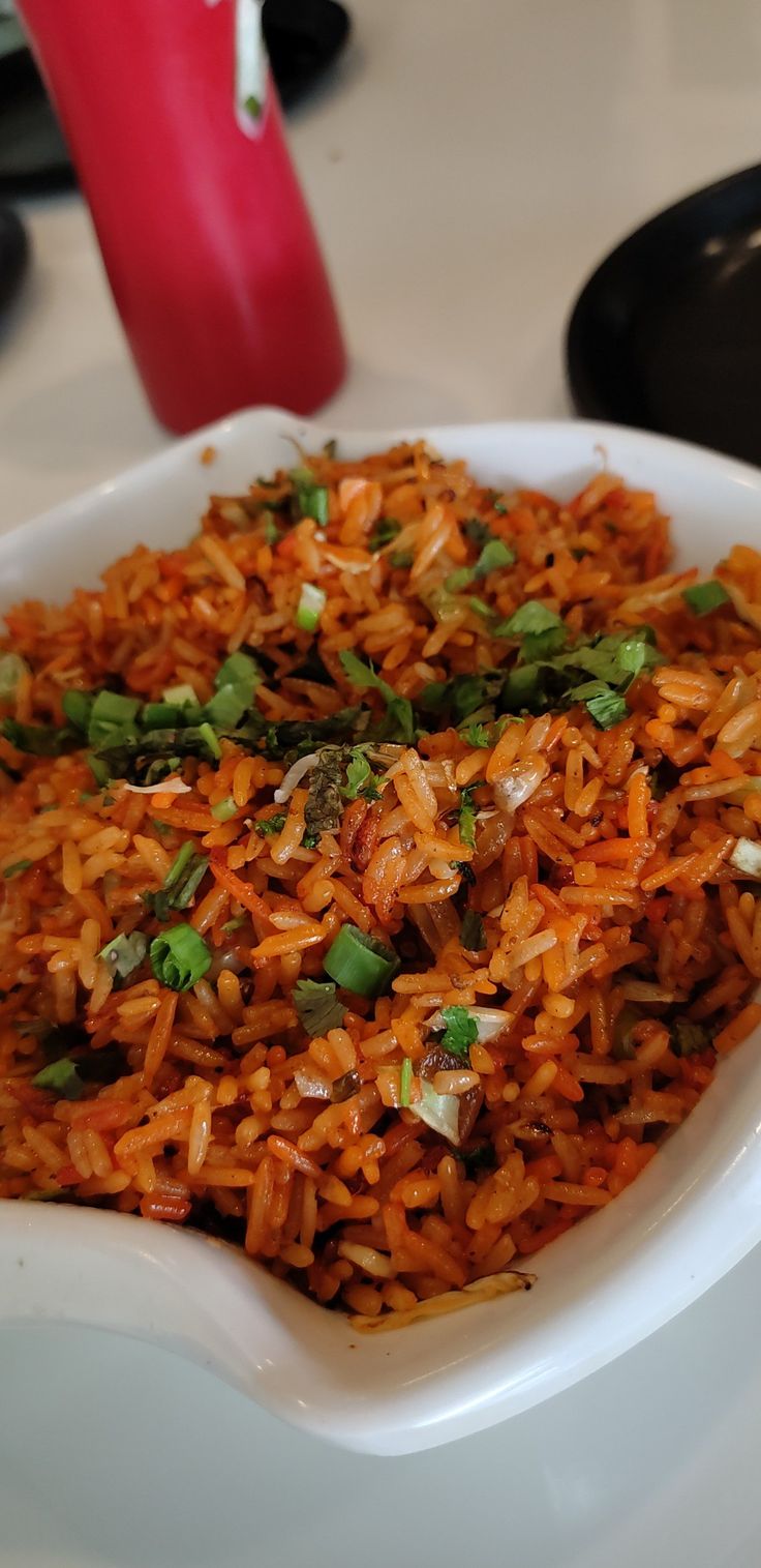 a white bowl filled with lots of food on top of a table