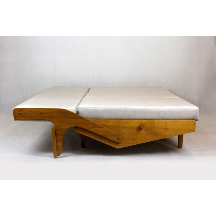 a bed that is sitting on top of a wooden frame with two drawers underneath it