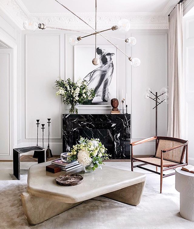 an elegant living room with white walls and marble coffee table in front of the fireplace