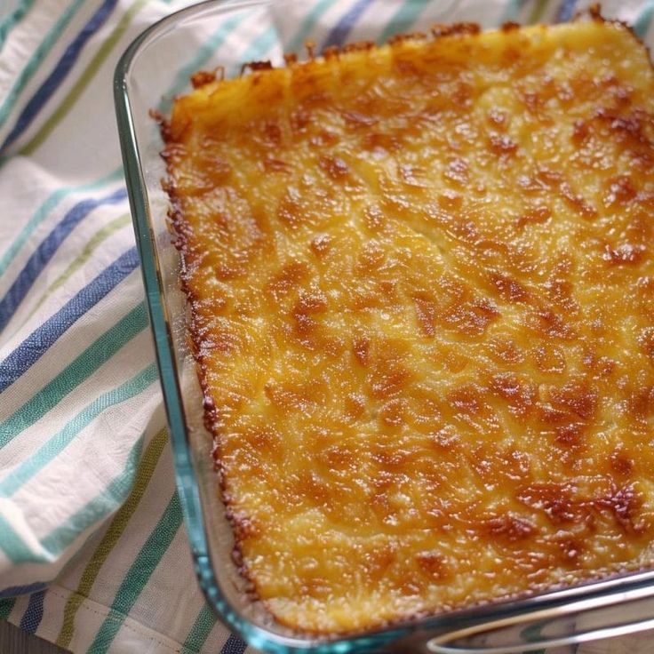 a casserole in a glass dish on top of a blue and white towel