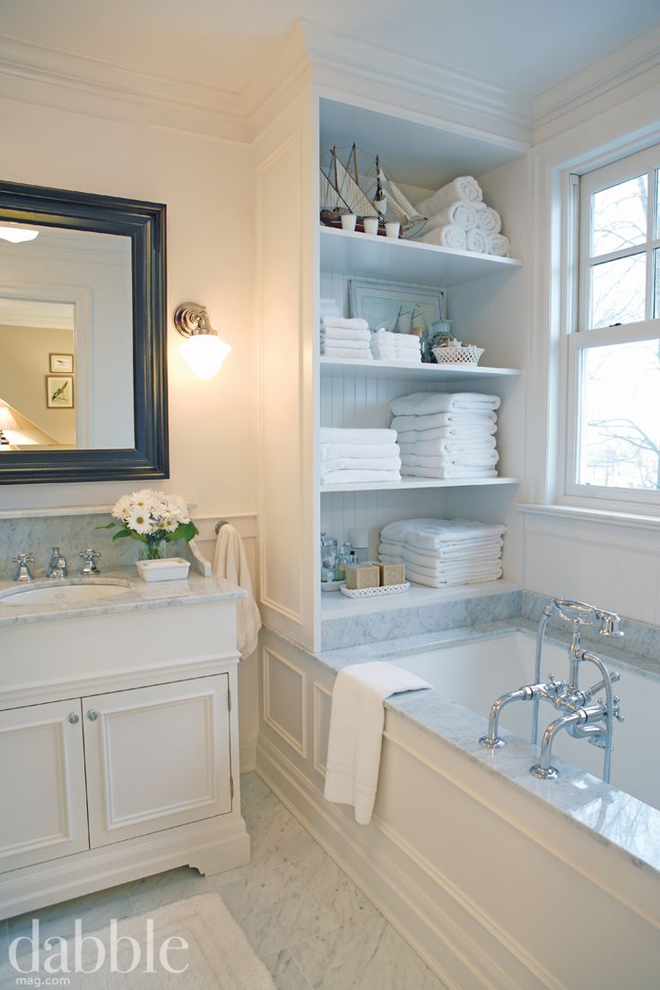 a bath room with a tub a sink and a mirror