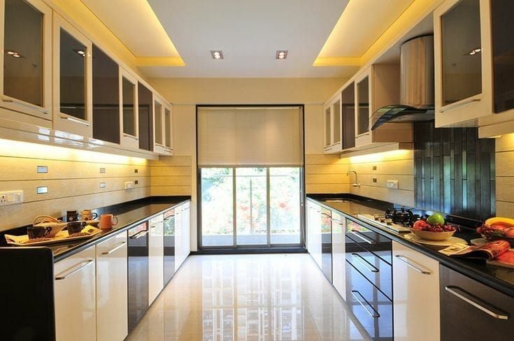 an empty kitchen with black counter tops and white cupboards on the walls, along with glass doors