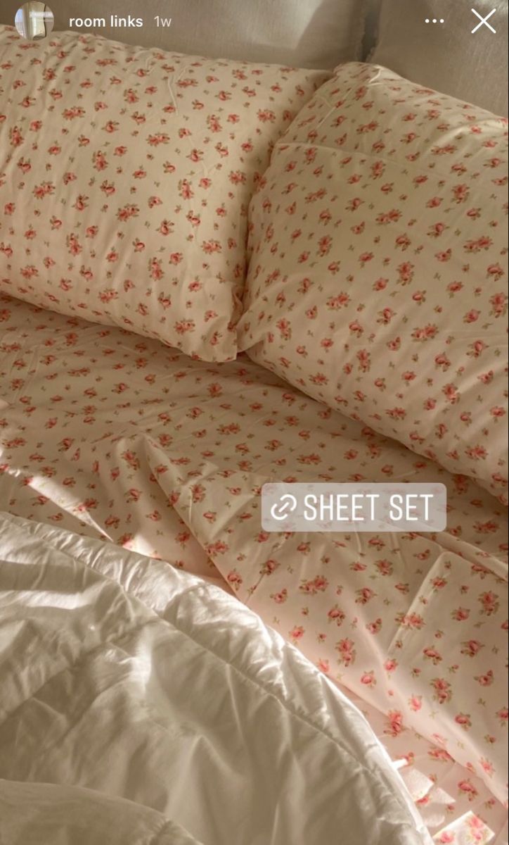 an unmade bed with white sheets and red flowers