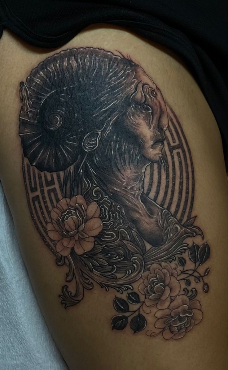 a woman's thigh with an artistic tattoo design on her thighs and the image of a lion