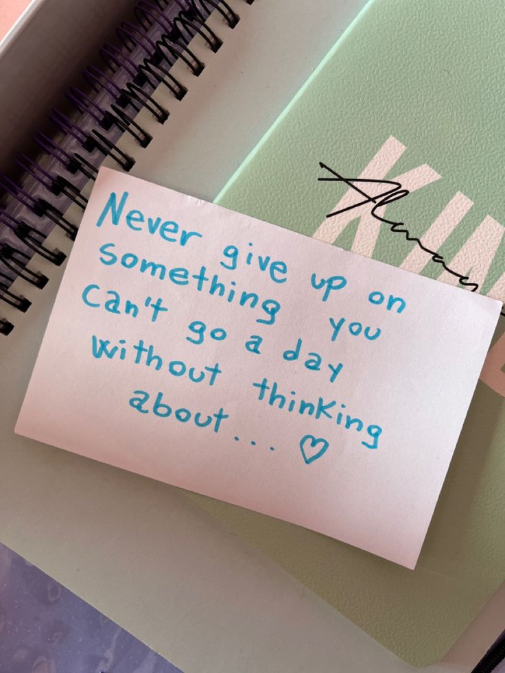 a note attached to a notebook with writing on it