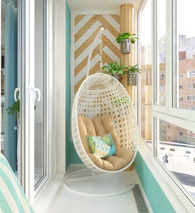 a white hanging chair in front of a window