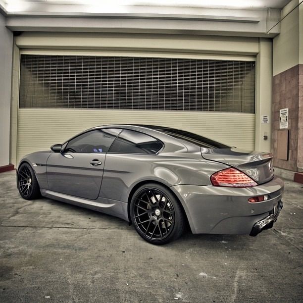 a grey sports car parked in front of a garage