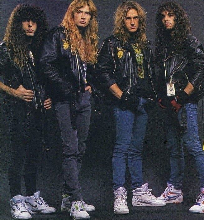 the group of young men in leather jackets and jeans are posing for a photo together