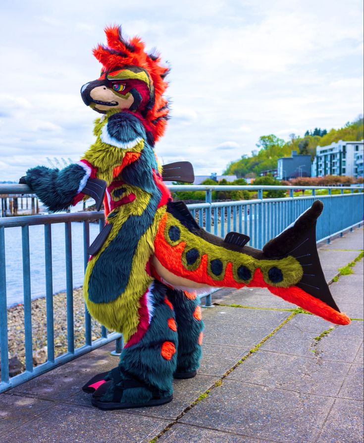 a person in a dragon costume standing next to a fence