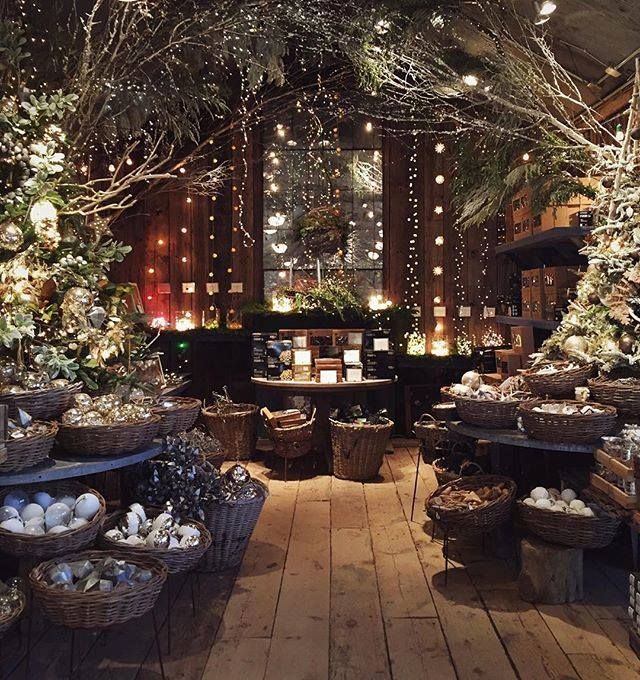 a room filled with lots of christmas trees and baskets full of presents on the floor