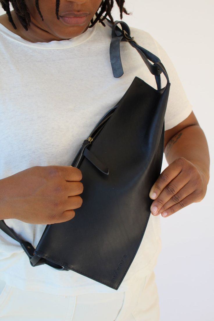 Elevated and functional, the Offset Sling's folded geometric panels add up to an asymmetrical statement piece. Stow a phone, keys, and wallet safely with a concealed zipper that stay close to the chest. The shoulder strap is adjustable with a single Conway-style buckle. This bag fits our Wallet and Cardholder beautifully. Unlined matte leather. Measures 13" wide and 7" deep. 1" wide shoulder strap, adjustable from 20" to 50" long. Sleek Bag With Adjustable Strap, Modern Leather Bag With Fold Over Clasp, Modern Adjustable Rectangular Bag Strap, Modern Shoulder Bag With Turn-lock Closure, Modern Crossbody Shoulder Bag With Turn-lock Closure, Sling Bags Women, Diy Clothes Hacks, Leather Conditioner, Shopper Bag