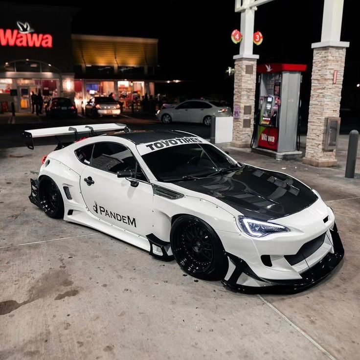 a white sports car parked in front of a store