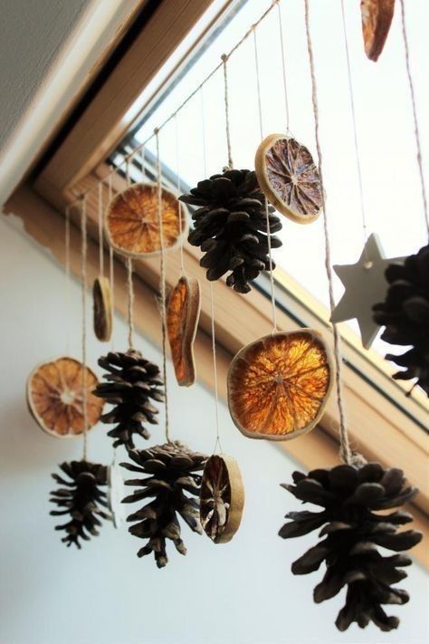 pine cones hanging from the side of a window sill with other decorations on it