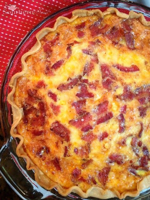 a bacon and cheese pie sitting on top of a red tableclothed table cloth