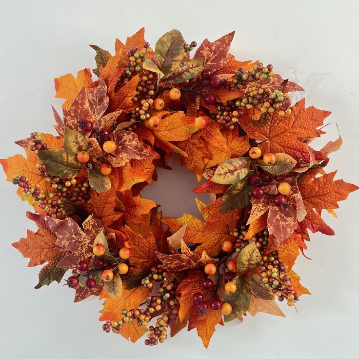 a wreath with leaves and berries on it