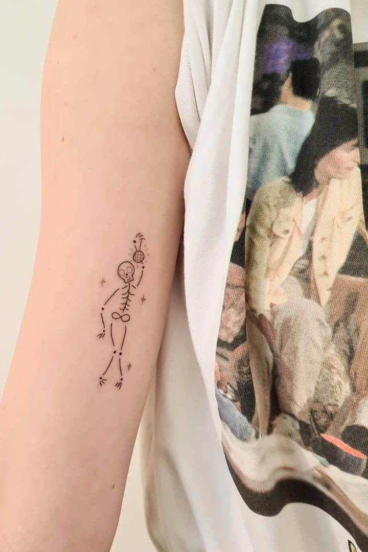 a woman's arm with a small tattoo design on the back of her left arm