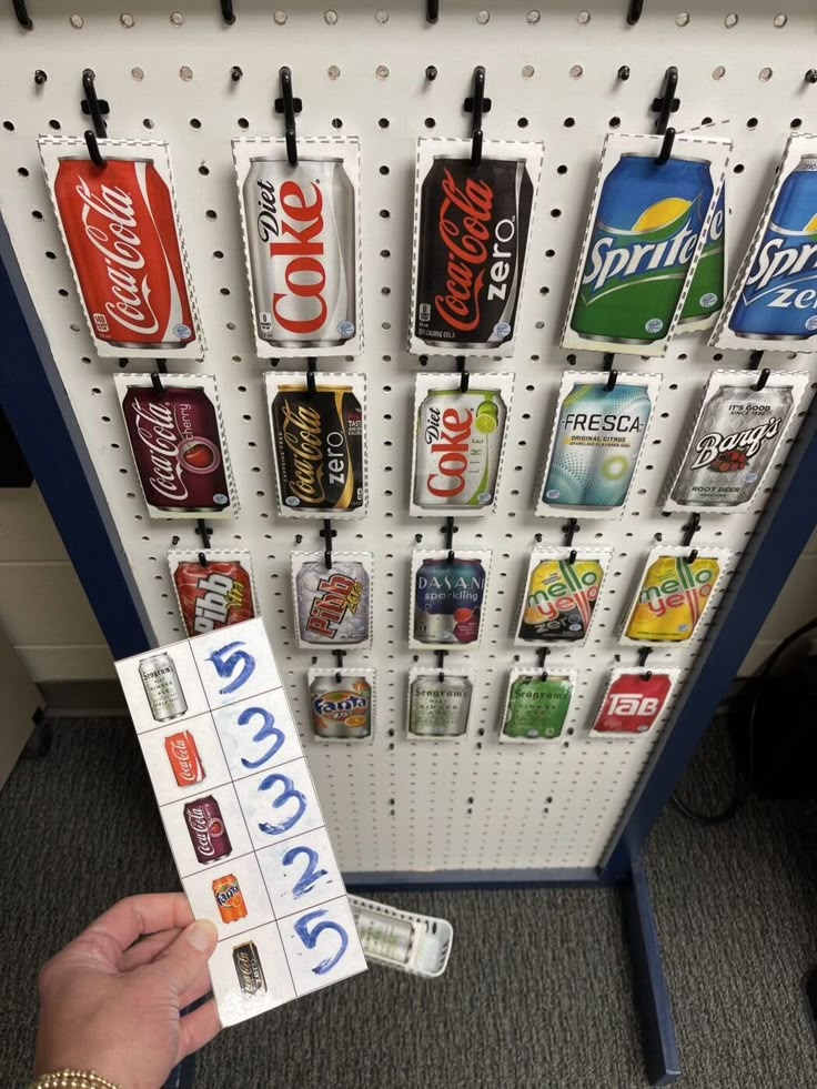 a person holding up a sign in front of a soda rack